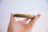 Side profile of the antique bronze cuff showing its solid thickness and weathered patina.