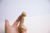 Close-up showing the smooth, hand-formed tip of the antique bronze bracelet.