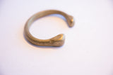 Aged patina on the hand-worked, rounded terminal of an African bronze cuff.
