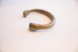 Detail of the sculpted snake head and aged patina on the bronze cuff.