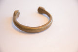 Profile view of the antique bronze snake cuff's curved shape and handmade finish.