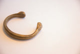 Hand-stamped markings on the snake head end of an antique bronze cuff.