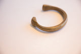 The graceful curve and warm, aged patina of the antique bronze snake cuff.