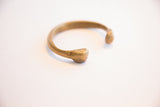 Aged brass patina and hand-worked details on an antique snake cuff's head.