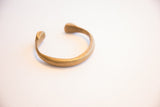 Profile of the antique African cuff bracelet with its stamped detailing and open form.