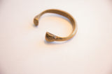 Close-up of the snake cuff terminal, showing its hand-formed shape and patina.