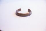 Front view of the antique African snake cuff, highlighting its aged metal texture.
