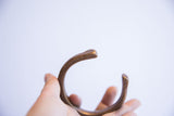 The open ends of the antique African snake cuff showing aged, textured metal.