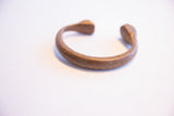 Angled profile of the antique African cuff showing its C-shape and time-softened patina.