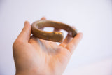 Angled view of the antique snake cuff, highlighting its substantial, smooth form.