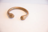 The open design and solid, curved form of the antique African snake cuff.