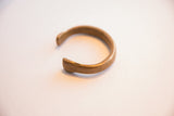 The open end of the antique snake cuff, showing its solid, handmade form and aged patina.