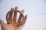 Antique African bronze cuff bracelet held in hand to demonstrate its substantial scale.