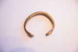The open C-shape form of the antique African snake cuff bracelet.