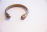 Aged patina and subtle engraved markings on the ends of an African snake cuff.
