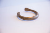 Side profile of an antique African snake cuff showing its open shape and aged patina.