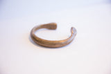 Side profile of the antique African cuff showing its open, curved shape.