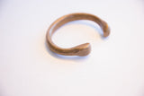 Angled view of the antique snake cuff showing its curved body and flared terminal.