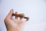 The smooth, rounded end of an antique African cuff showing its aged patina.