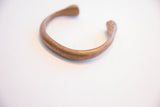 Finely etched line details following the smooth curve of the antique African bracelet.