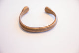 Angled view of the antique snake cuff showing its curved form and open ends.