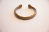 View of the antique snake cuff's smooth, open form and warm patina.