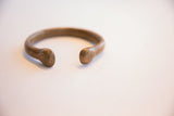 Close-up of the smooth, open-ended antique African cuff bracelet with an aged patina.