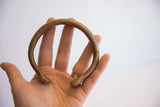 Antique African snake cuff bracelet held in hand, showing its solid, round form.