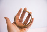 Antique African snake cuff bracelet held to show its scale and smooth, worn finish.