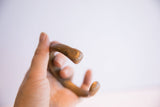 Antique African snake cuff bracelet held in hand, showing its scale and smooth patina.