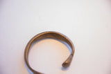 The open end and curved form of a handmade antique snake cuff bracelet.