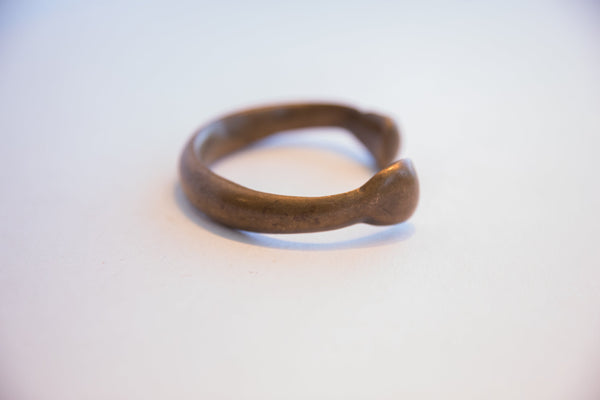 Side profile of the antique snake cuff showing its hand-formed curve and aged patina.