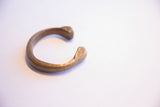 The antique African snake cuff in profile, highlighting its open design and terminals.