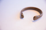 The open form and rounded terminals of the antique snake cuff bracelet.
