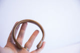 Antique African snake cuff bracelet held in hand, showing its substantial form and scale.