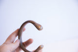 Smooth C-curve and rounded terminal of the antique handmade African cuff bracelet.