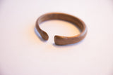The solid, open form of the antique African bracelet with a smooth, aged finish.