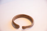 The smooth, open ends and curved shape of the antique African cuff.