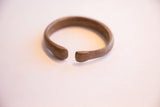 View of the antique African cuff's opening showing its rounded ends and worn patina.