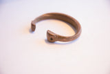 Angled view of the handmade terminal on the antique African cuff bracelet.