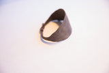 Close-up of the vintage African bracelet's rustic brown patina and curved edge.