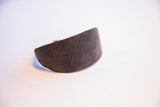 Close-up of the vintage African bracelet's textured, earthy brown surface with rich patina.