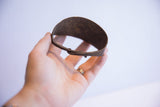 Vintage African bracelet in hand, showcasing its unique patinated bronze surface.