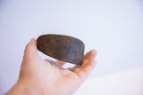Rustic dark brown patina on a curved segment of the vintage African bracelet.