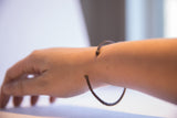 Vintage African cuff bracelet with a segmented, dark metal design worn on a wrist.