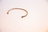 Hand-forged curled terminal on a vintage African thin cuff bracelet.