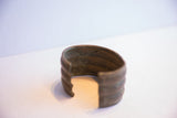 The opening of the wide African cuff bracelet reveals its aged, textured interior patina.