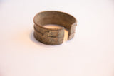 Hand-etched geometric patterns and aged patina near the vintage cuff's opening.