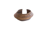 Vintage African cuff bracelet with a flared shape, embossed details, and a dark, aged patina.