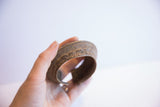 The aged, rustic surface and smooth curved interior of the African cuff bracelet.